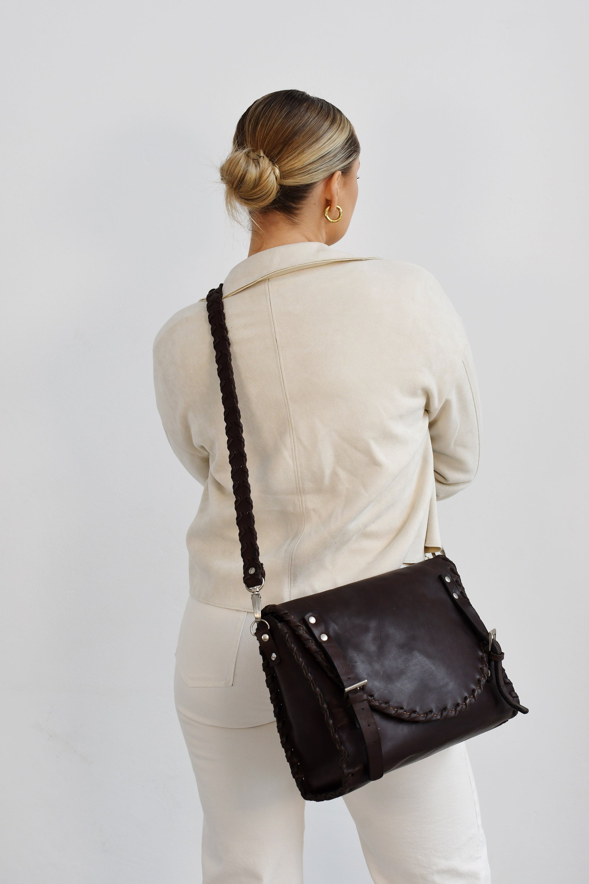 A dark brown leather cross body bag with multiple compartments and a buckle closure. Handcrafted in Cape Town, R1,530